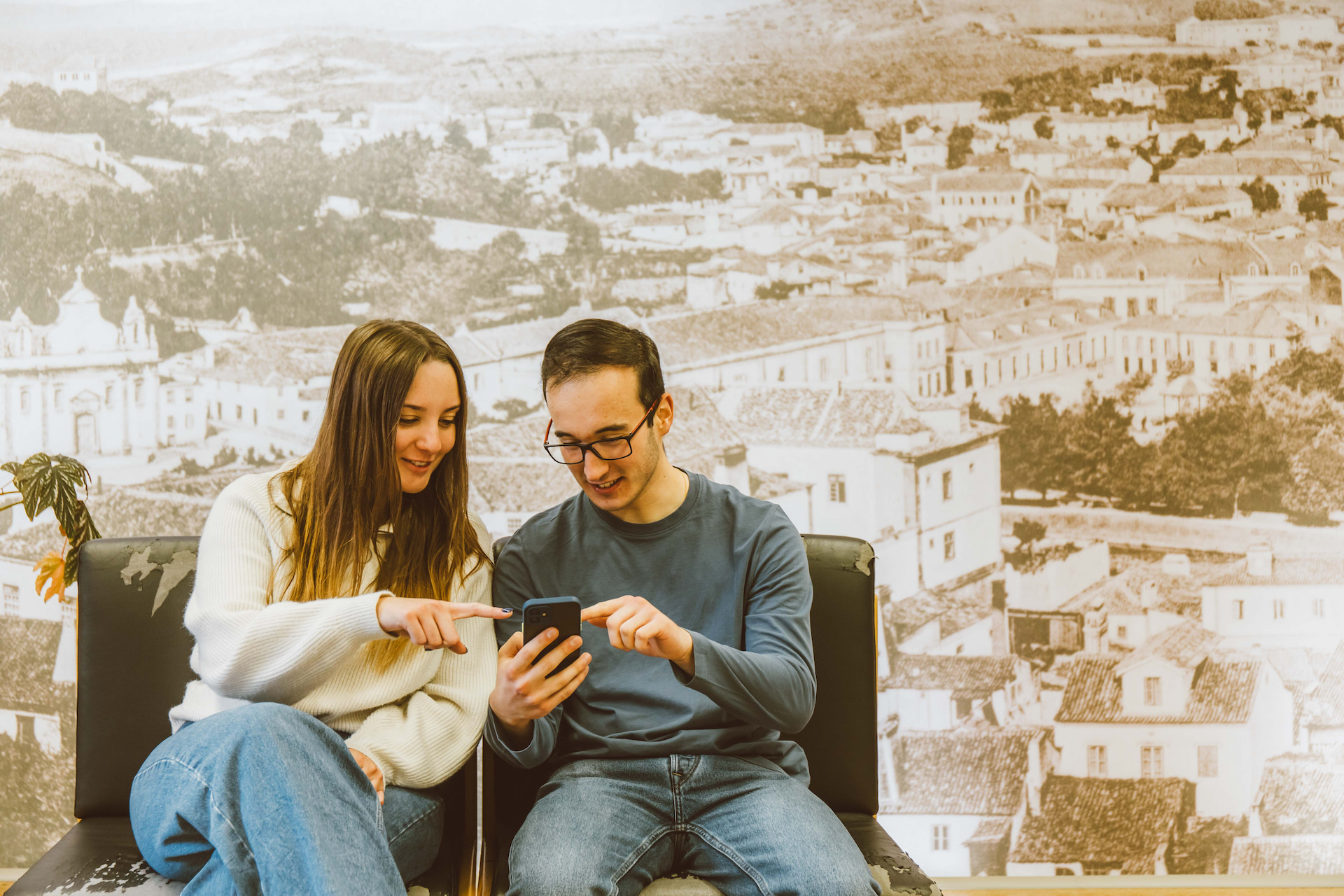 rapariga e rapaz a ver e cometar informação em telemóvel